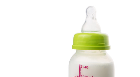 Milk in a baby bottle over white backgroundの写真素材