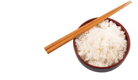 A bowl of rice and a pair of chopstick over white backgroundの写真素材