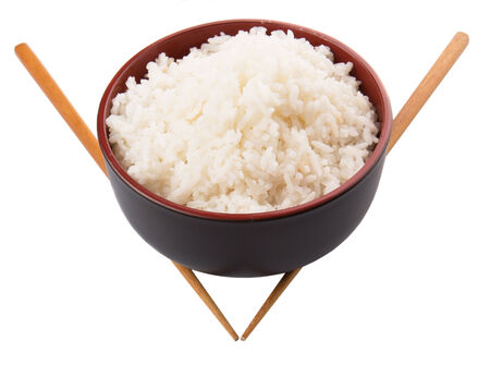 A bowl of rice and a pair of chopstick over white backgroundの写真素材