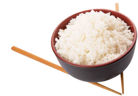 A bowl of rice and a pair of chopstick over white backgroundの写真素材