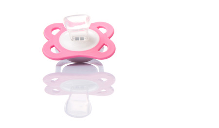 A pink pacifier over white backgroundの写真素材