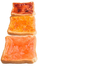 Mix fruit, blueberry, orange fruit jam spread on bread toast over white backgroundの写真素材