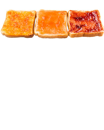 Mix fruit, blueberry, orange fruit jam spread on bread toast over white backgroundの写真素材