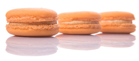Orange colored French macarons over white backgroundの写真素材