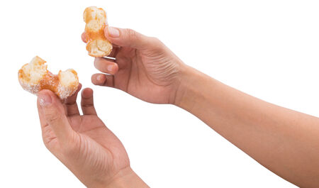 Female hand holding doughnuts over white backgroundの写真素材