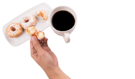 Female hand holding doughnuts with a mug of coffee over white background