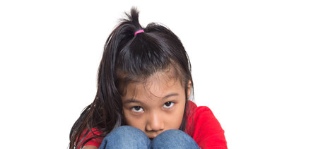 Sad and depressed young Asian girl over white background