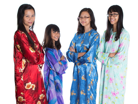 Asian Malay mother and daughters in traditional dress over white backgroundの写真素材