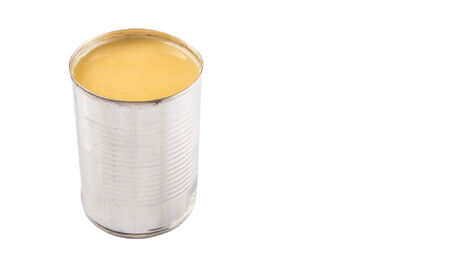 Condensed milk in tin can over white backgroundの写真素材