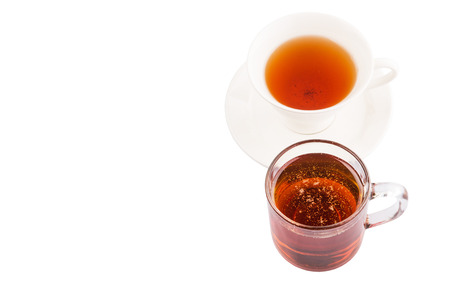 A cup of tea and a jar of honey over white backgroundの写真素材
