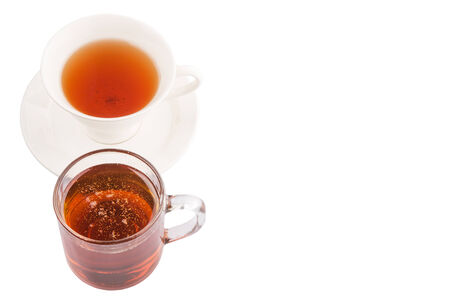 A cup of tea and a jar of honey over white backgroundの写真素材