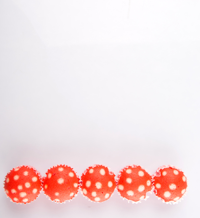 Malaysian red colored steamed rice polka dot muffin or apam polka dot on white backgroundの写真素材