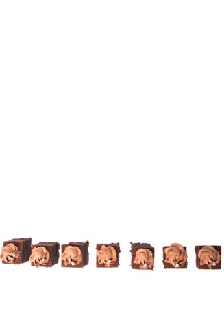 Bite sized chocolate cake with icing on top over white backgroundの写真素材