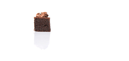 Bite sized chocolate cake with icing on top over white backgroundの写真素材