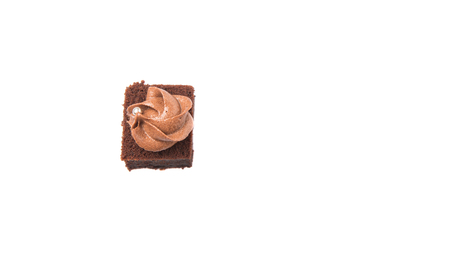 Bite sized chocolate cake with icing on top over white backgroundの写真素材