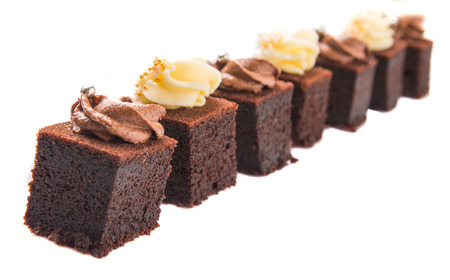 Bite sized chocolate cake with chocolate and cream cheese toppingsの写真素材