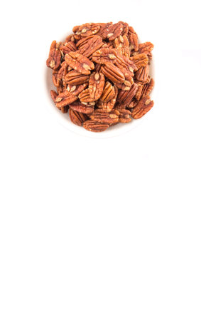 Pecan nut in a white bowl over white backgroundの写真素材