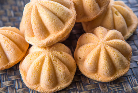 Kuih bahulu, a Malay sweet egg sponge cake on wicker mat.