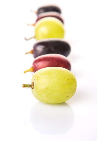 Red, green and black grapes fruits over white background