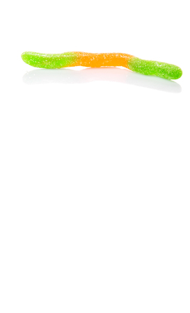 Green and orange sugar jelly candy strip over white backgroundの写真素材
