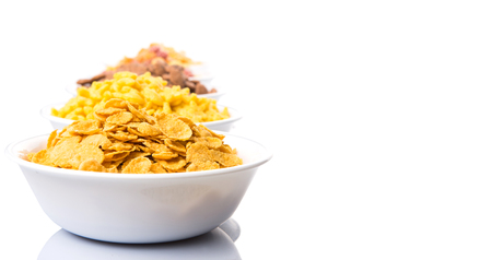 Mix variety of breakfast cereal in white bowls over white backgroundの写真素材
