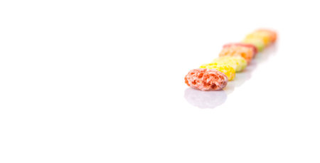 Colorful fruit flavored loops shaped cereal over white backgroundの写真素材