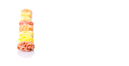 Colorful fruit flavored loops shaped cereal over white background