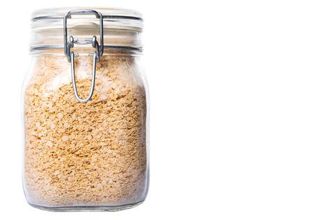 Whole grain breakfast cereal in a glass jar over white backgroundの写真素材