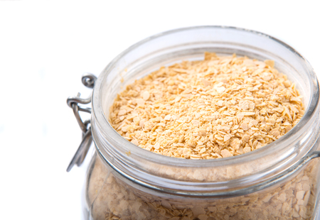 Whole grain breakfast cereal in a glass jar over white backgroundの写真素材