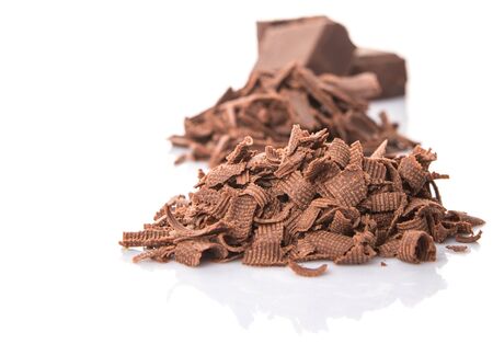 Dark brown chocolate pieces over white backgroundの写真素材