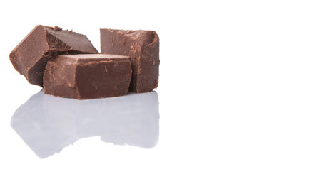 Dark brown chocolate pieces over white background