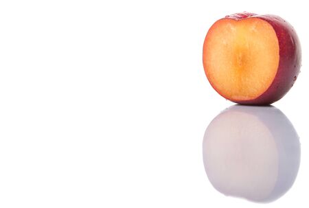 A slice of victoria plum or red plum over white backgroundの写真素材
