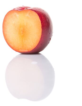 A slice of victoria plum or red plum over white backgroundの写真素材