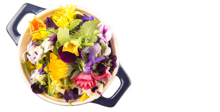 Mix edible flower salad in a blue single pot over white backgroundの写真素材
