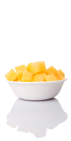 Bite size yellow watermelon in a white bowl over white backgroundの写真素材