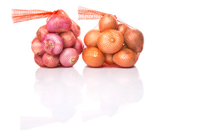Indian red onion and Dutch yellow onion in plastic sack over white backgroundの写真素材