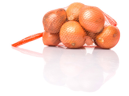 Dutch yellow onion in plastic sack over white backgroundの写真素材