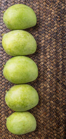 Green mango over wicker backgroundの写真素材
