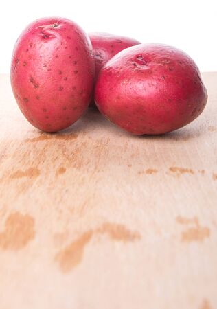 Red potatoes on wooden surfaceの写真素材