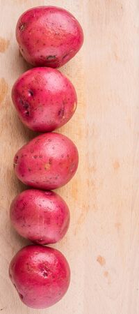 Red potatoes on wooden surfaceの写真素材
