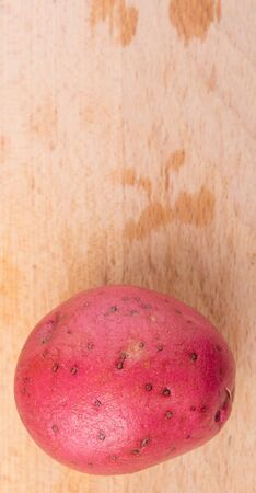 Red potato on wooden surfaceの写真素材