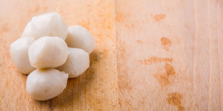 Raw white fish balls on a wooden surface