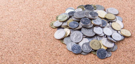 Pile of Malaysian coins on cork board surface