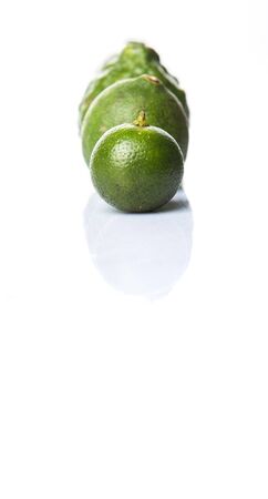 Lime makrut or kaffir lime and calamansi over white backgroundの写真素材