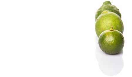 Lime makrut or kaffir lime and calamansi over white backgroundの写真素材