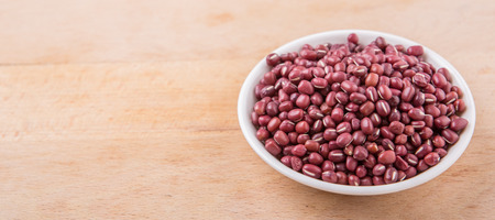 Red adzuki beans in white bowl over wooden backgroundの写真素材