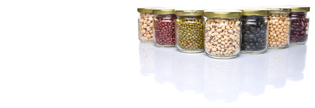 Black eye peas chickpeas adzuki beans mung bean soy beans black beans and red kidney beans in mason jars over white backgroundの写真素材