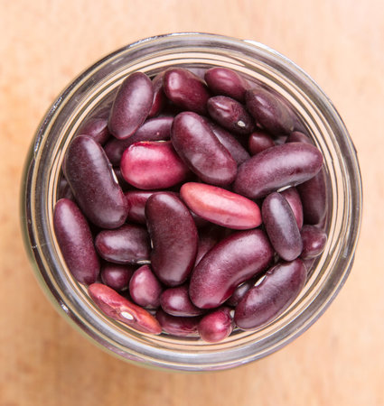 Red kidney beans in mason jar over wooden background