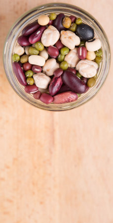 Mix beans of black eye peas mung bean adzuki beans soy beans black beans and red kidney beans in a mason jar over wooden backgroundの写真素材