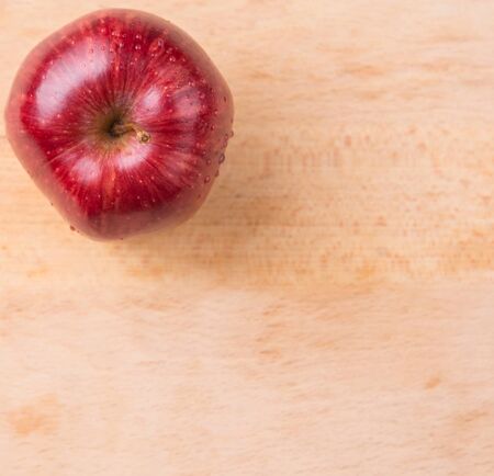 Red apple over wooden backgroundの写真素材